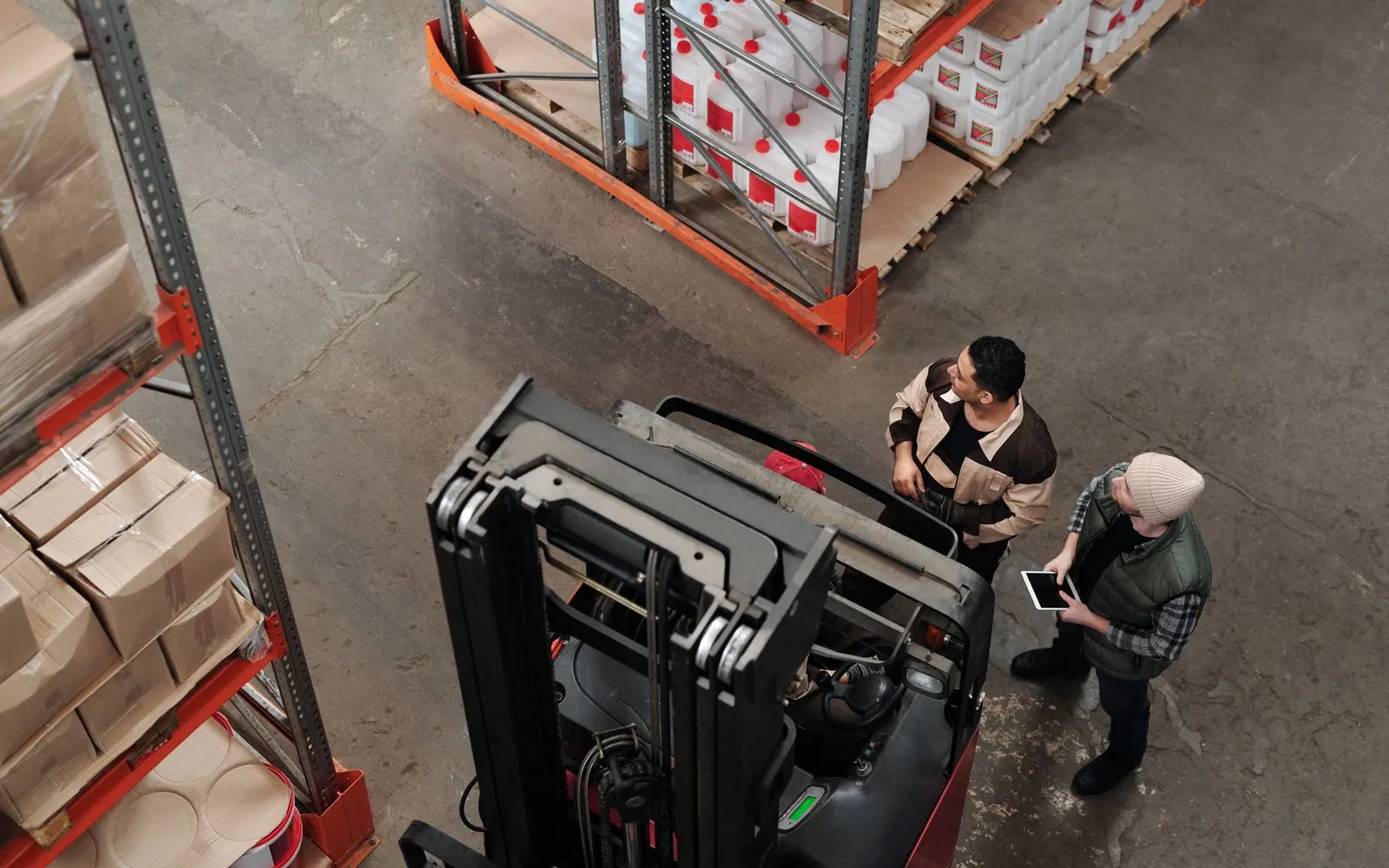 Two workers checking an inbound pallet of spent batteries at the receiving dock