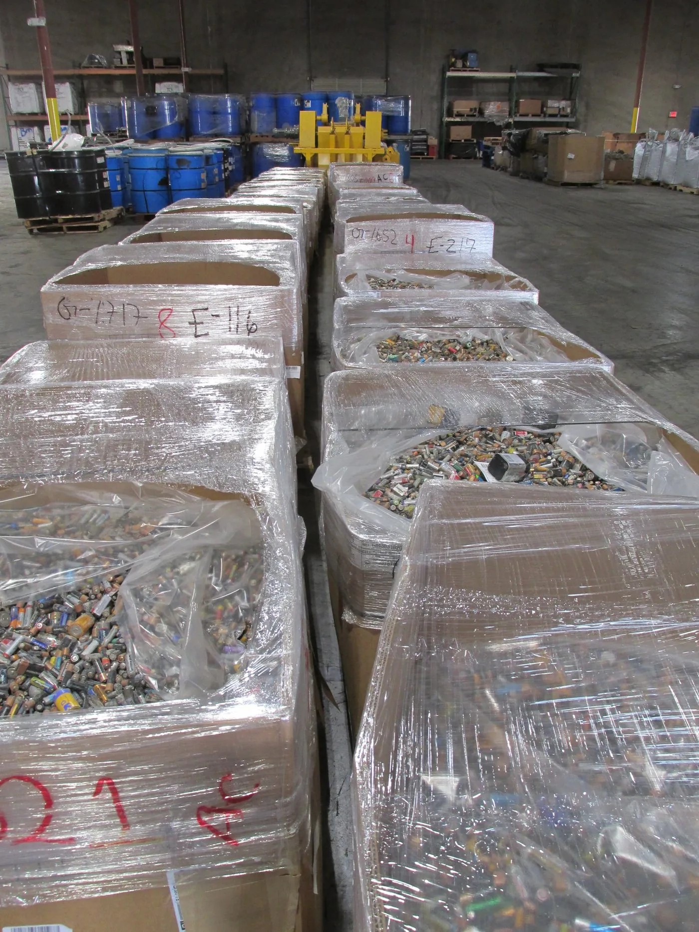 A trailer backed into the receiving dock, pallets being unloaded
