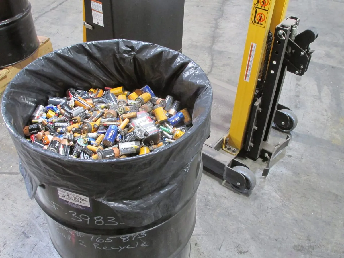 A five gallon pail with its lid and a few loose cells beside it